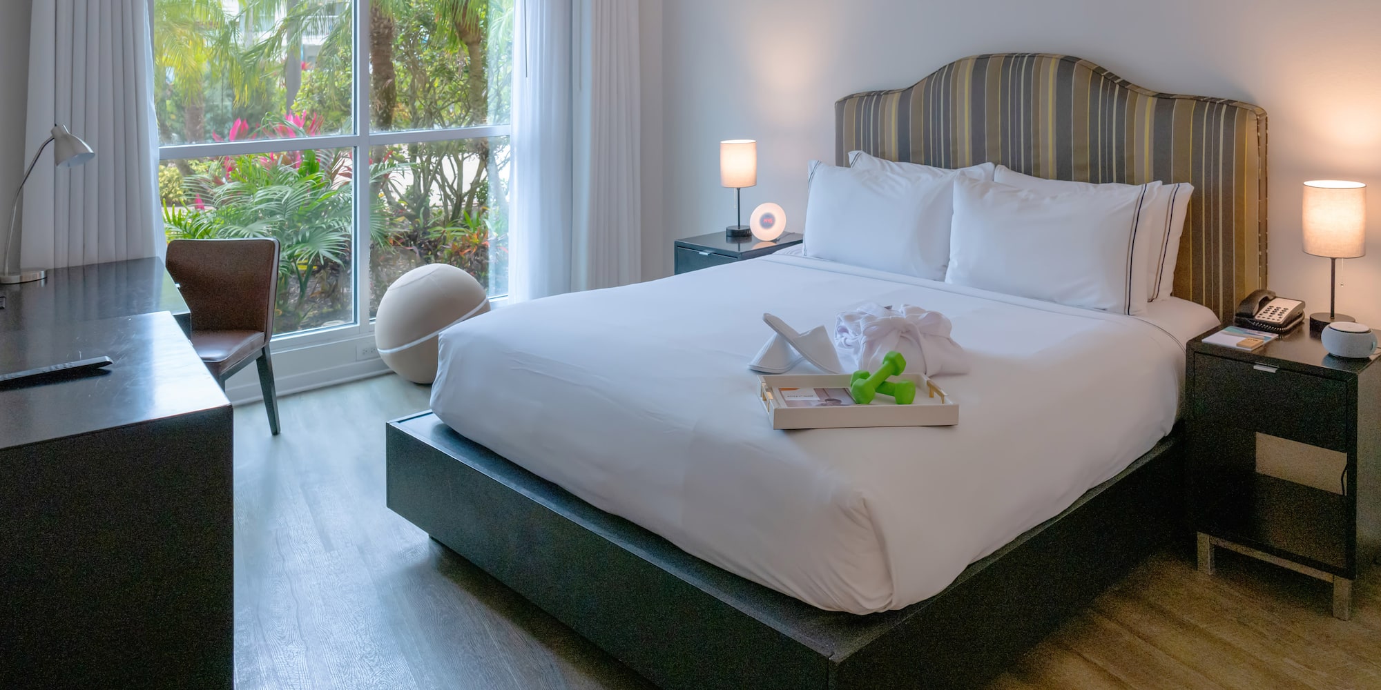 a bed with white sheets and a tray of toys on it