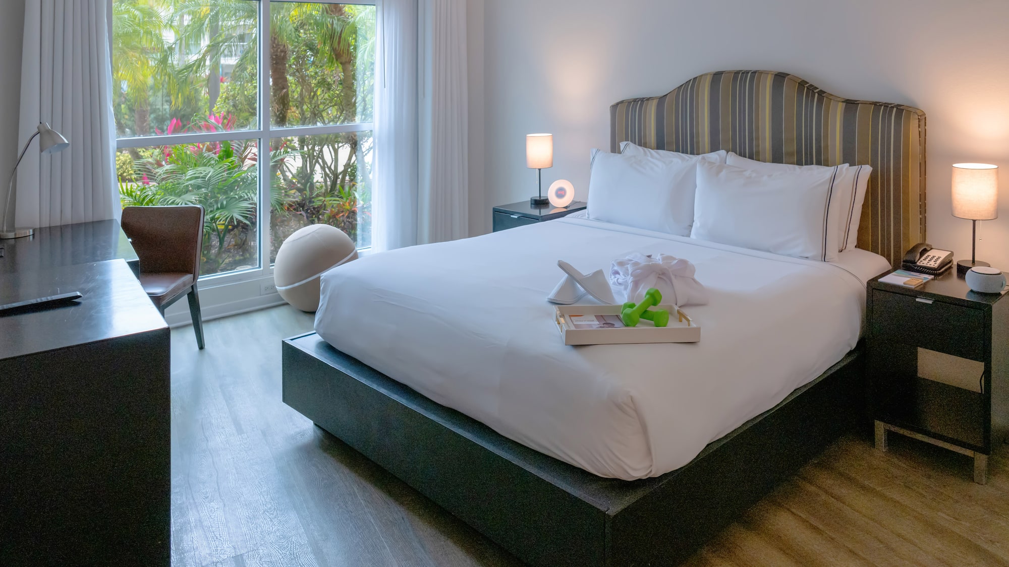 a bed with white sheets and a tray of toys on it