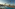 Luxury resort pool with palm trees, sun loungers, and ocean beach view.