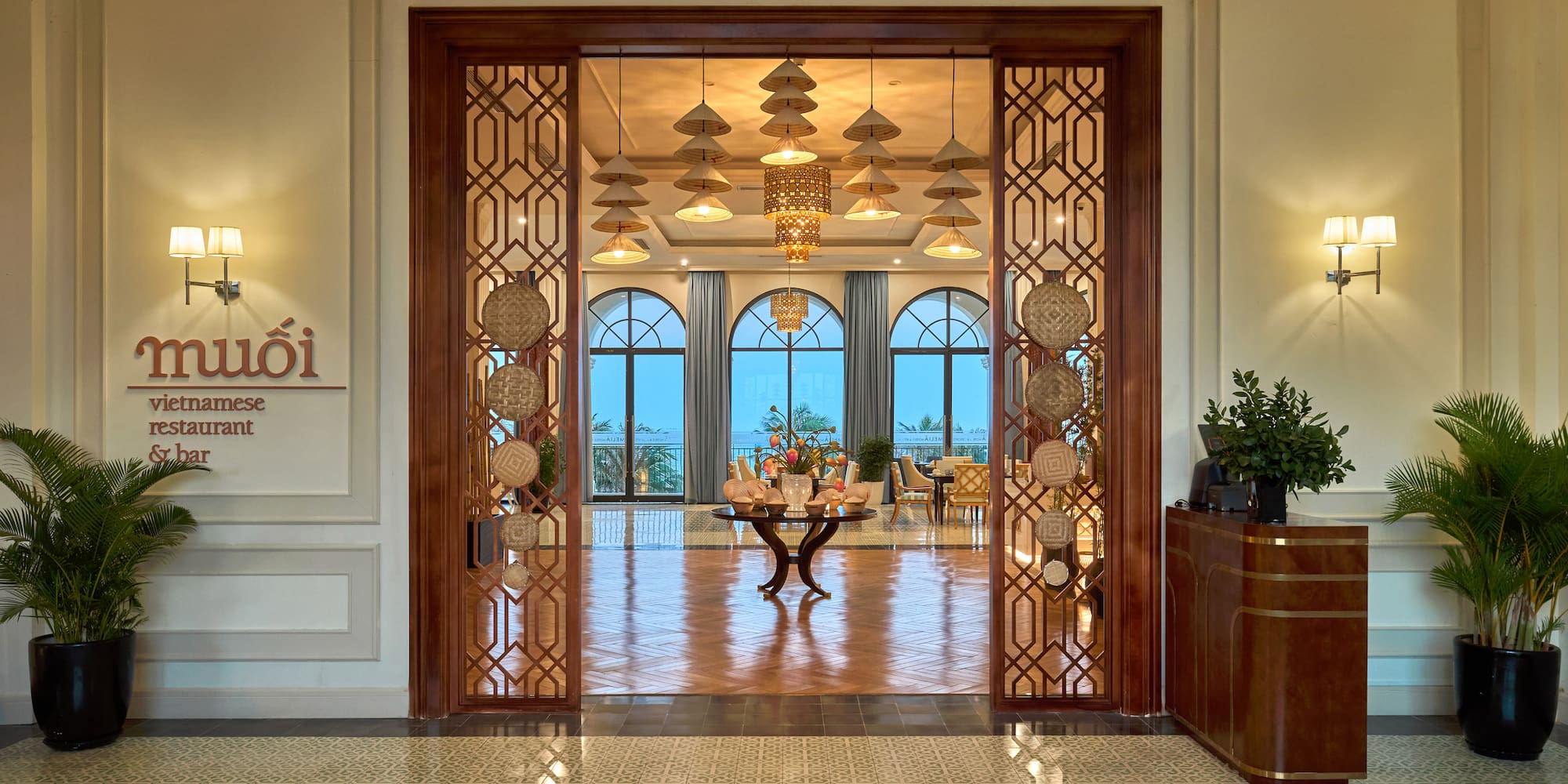 Muoi Vietnamese restaurant & bar entrance with elegant decor, arched windows.