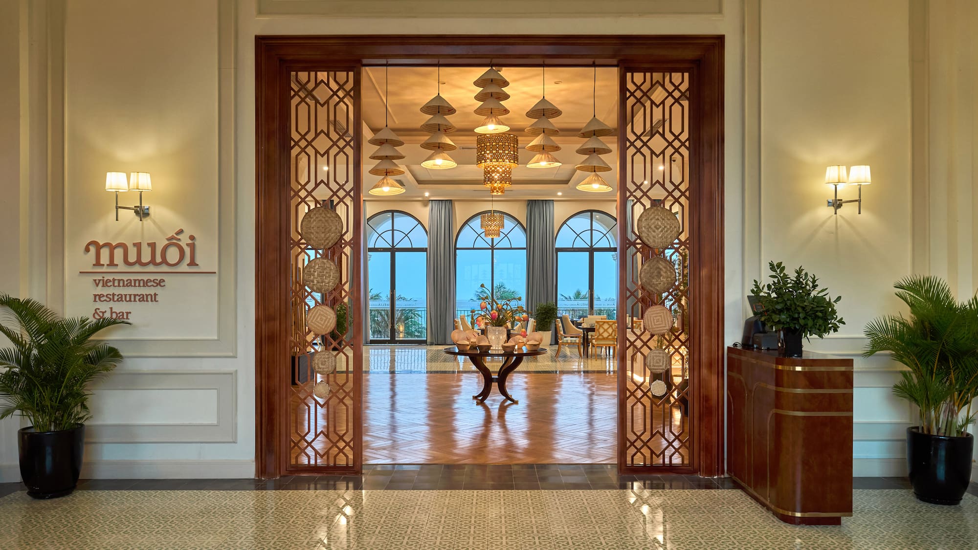 Muoi Vietnamese restaurant & bar entrance with elegant decor, arched windows.