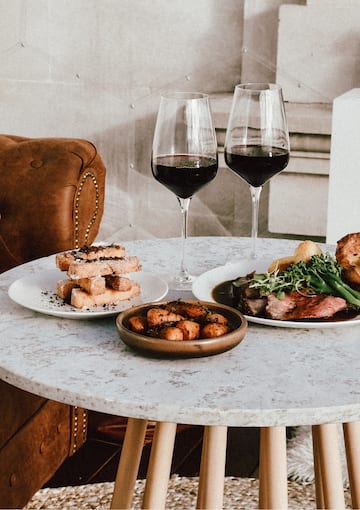 a table with plates of food and wine glasses