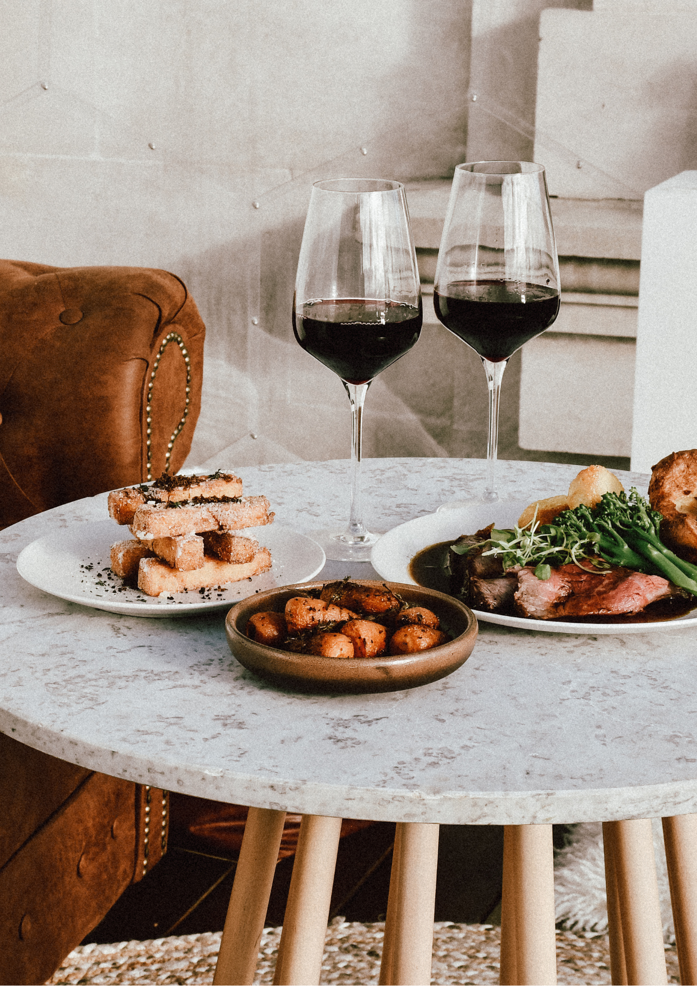 a table with plates of food and wine glasses