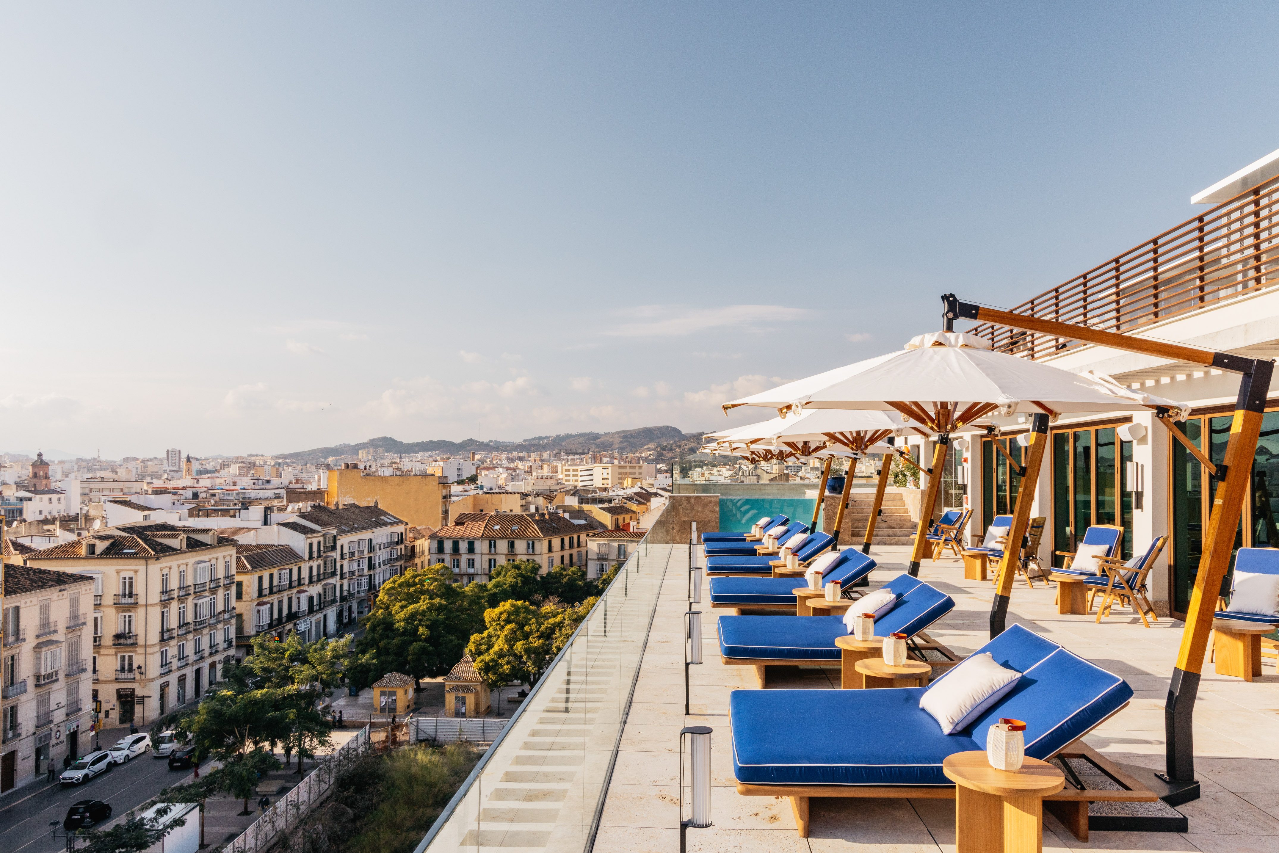 a deck with chairs and umbrellas on a rooftop