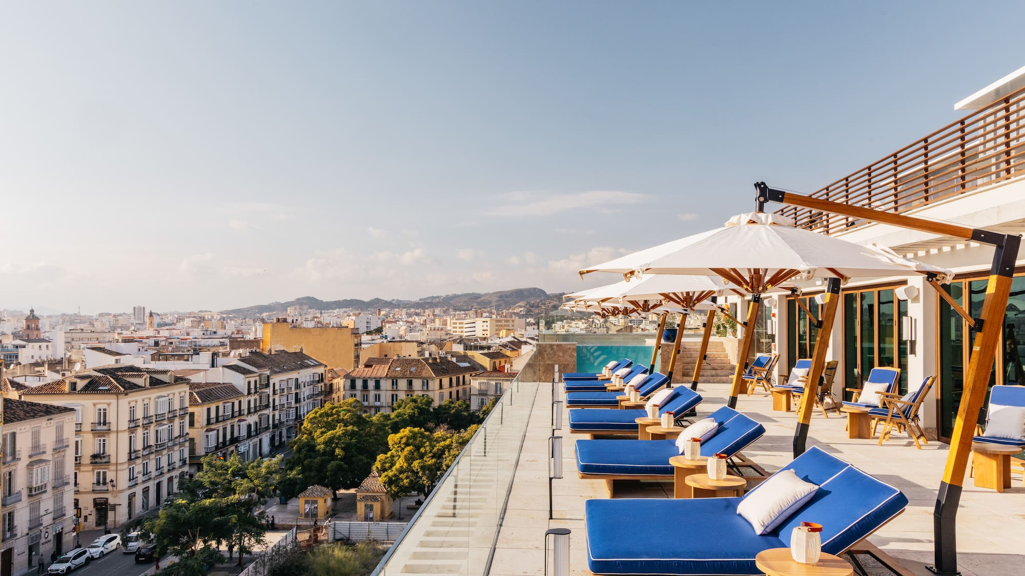 a deck with chairs and umbrellas on a rooftop