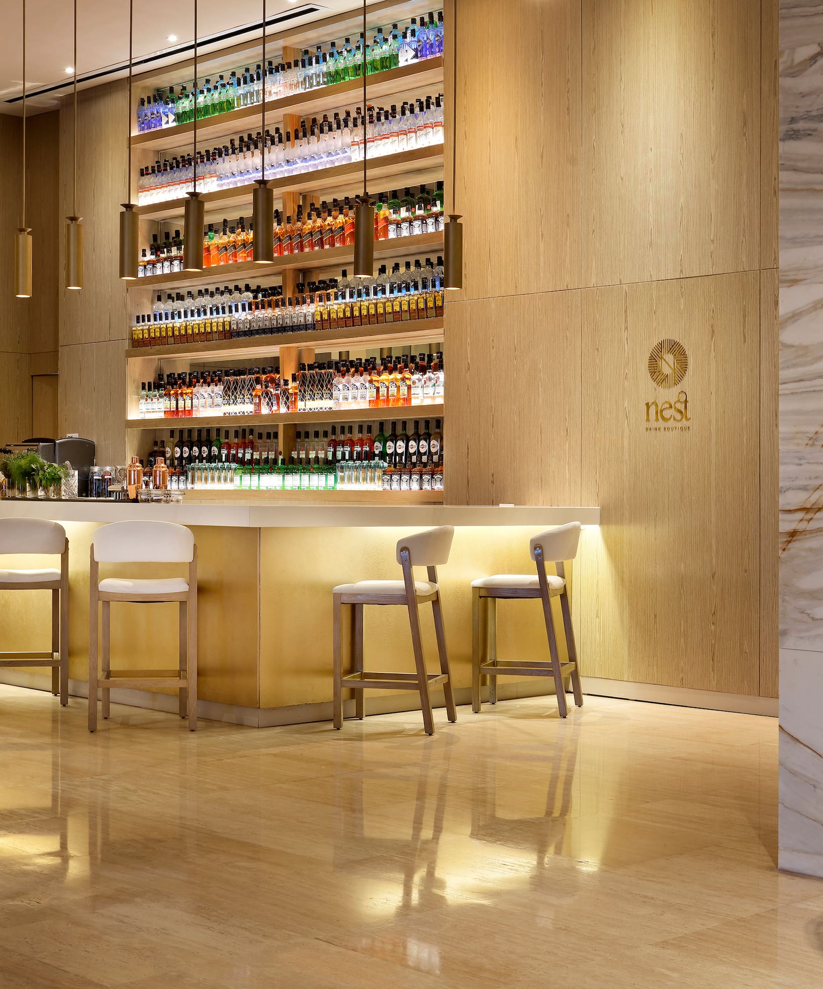 a bar with shelves of liquor and chairs