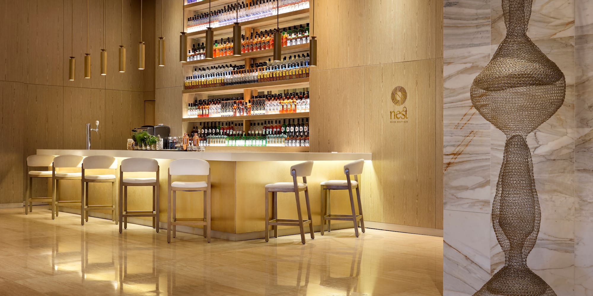 a bar with shelves of liquor and chairs