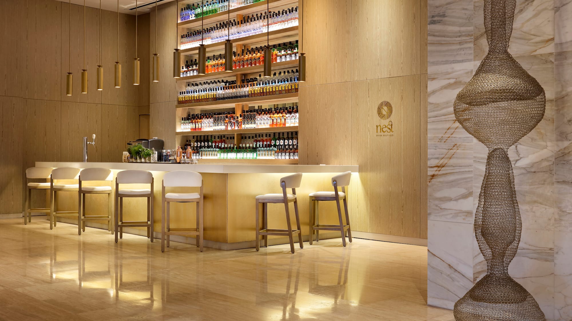 a bar with shelves of liquor and chairs