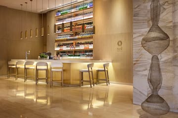 a bar with shelves of liquor and chairs