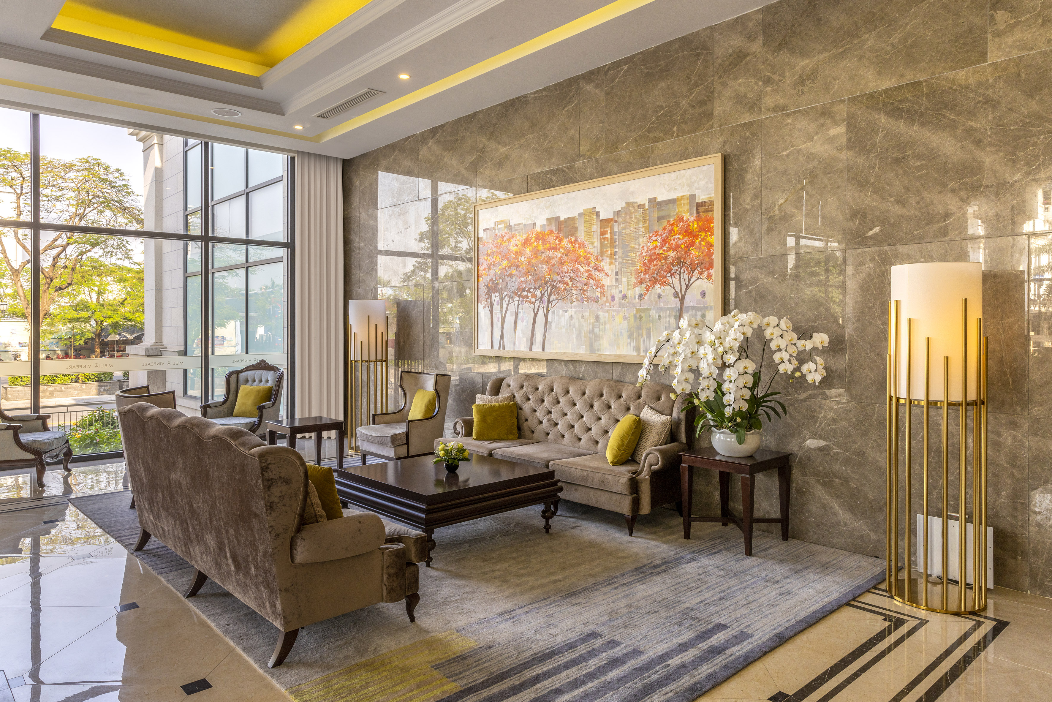 Elegant hotel lounge with plush seating, marble walls, and modern art.