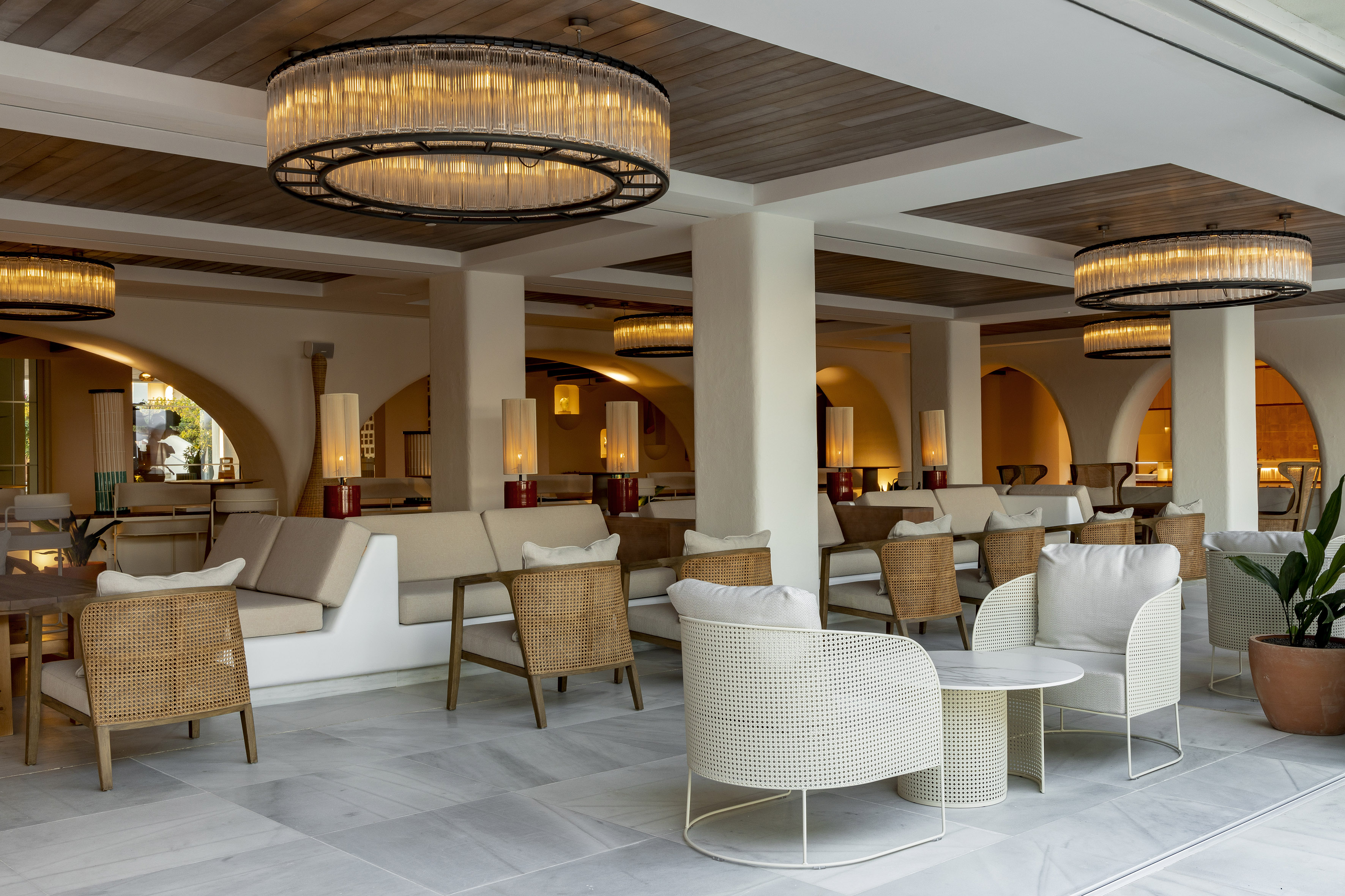 Chic resort lounge with grand chandeliers, stylish seating, and marble floors.