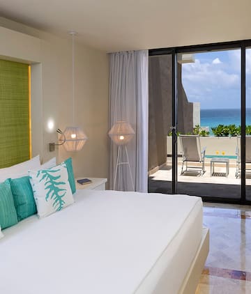 a bedroom with a glass door and a view of the ocean