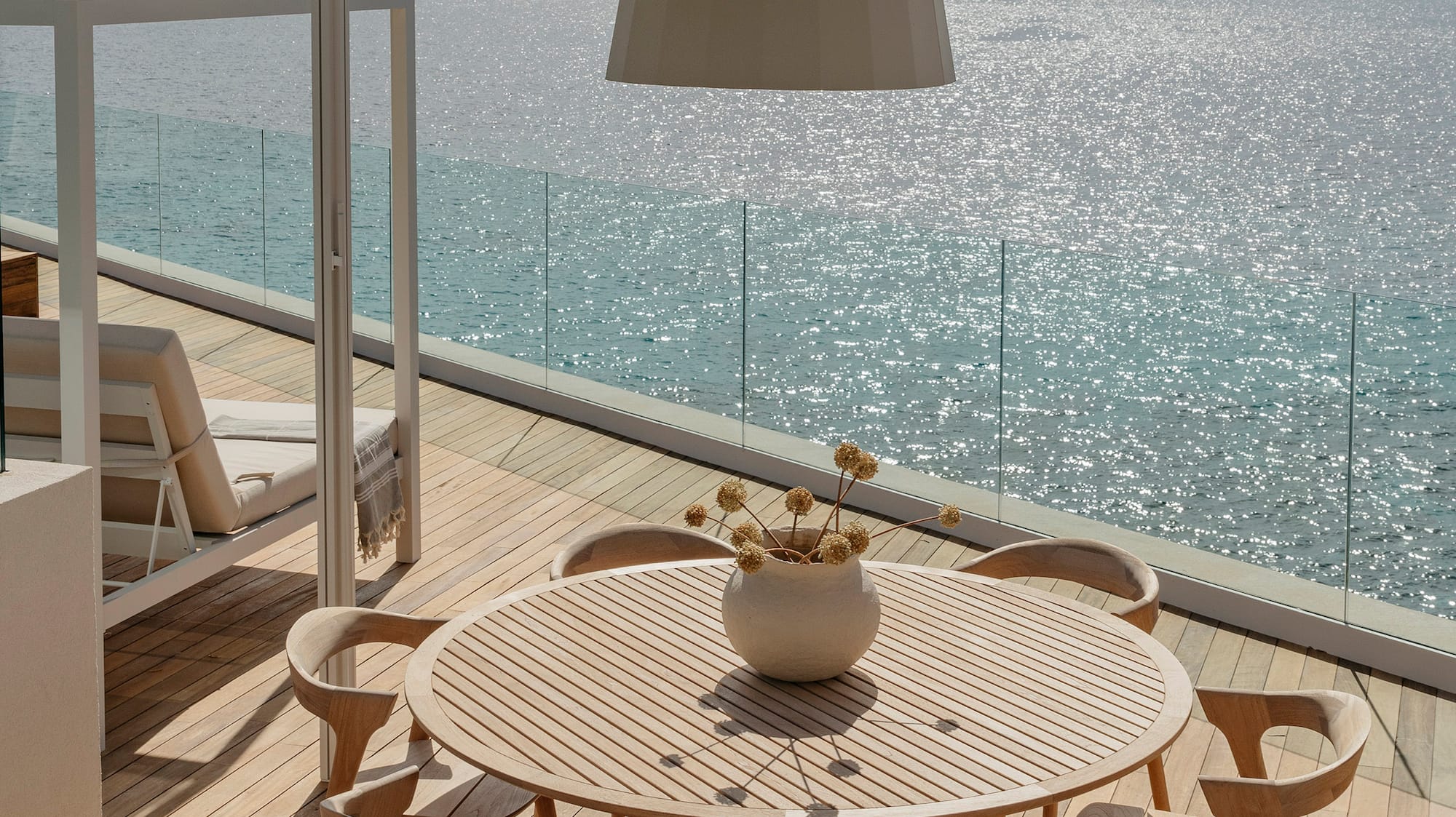 a table and chairs on a deck overlooking the ocean