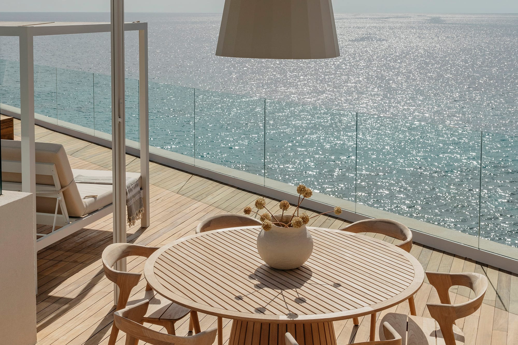 a table and chairs on a deck overlooking the ocean