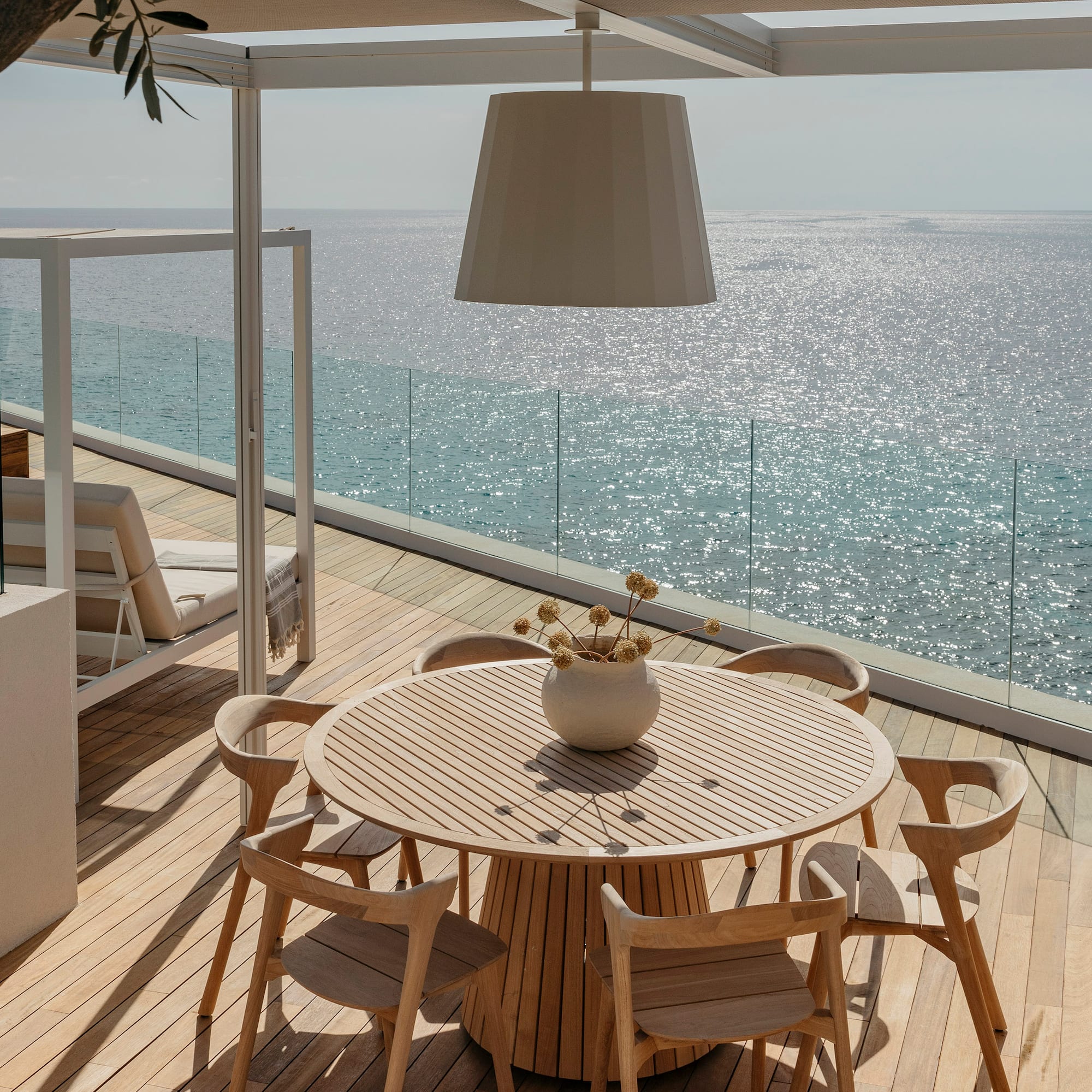 a table and chairs on a deck overlooking the ocean