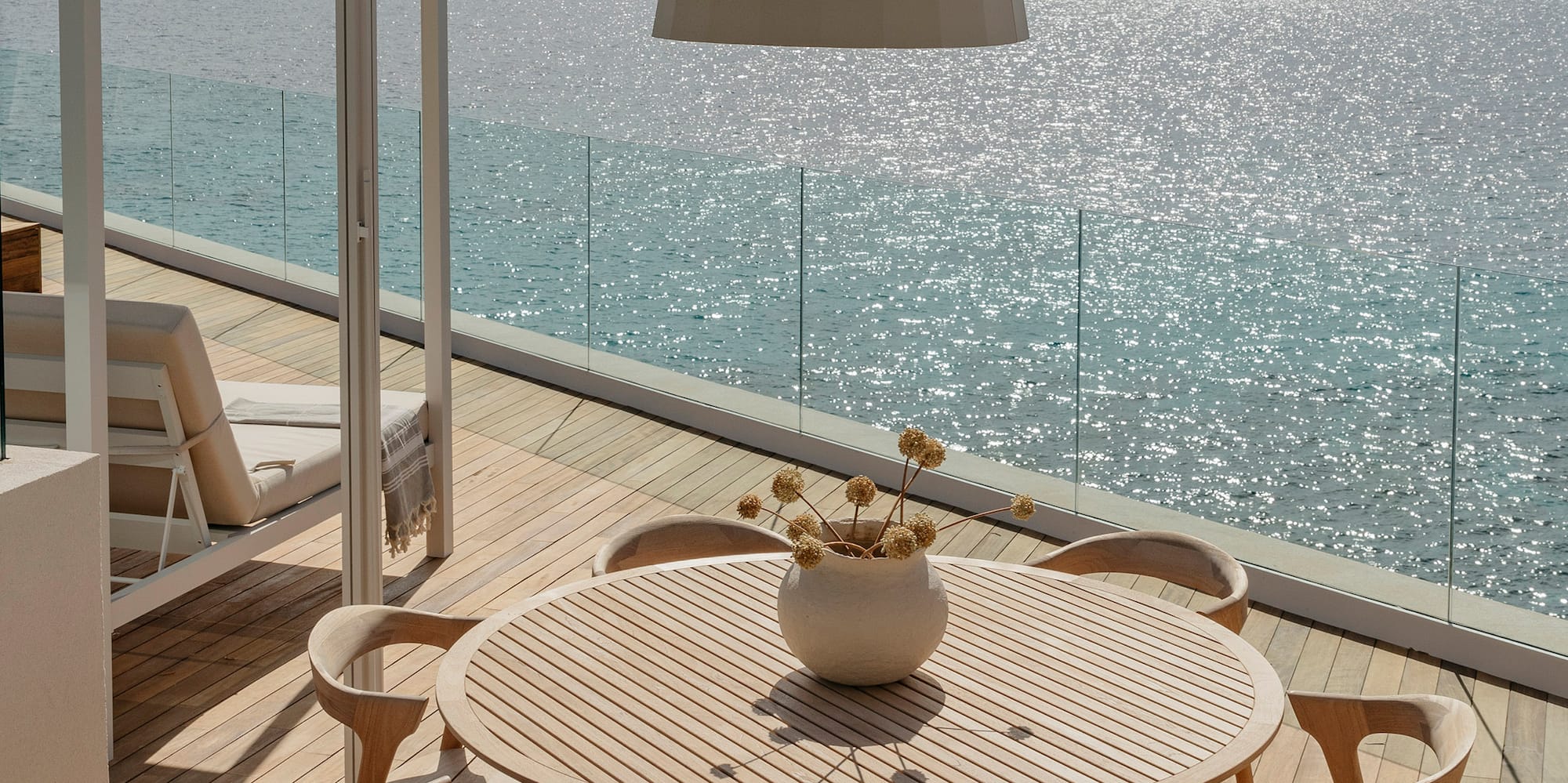 a table and chairs on a deck overlooking the ocean