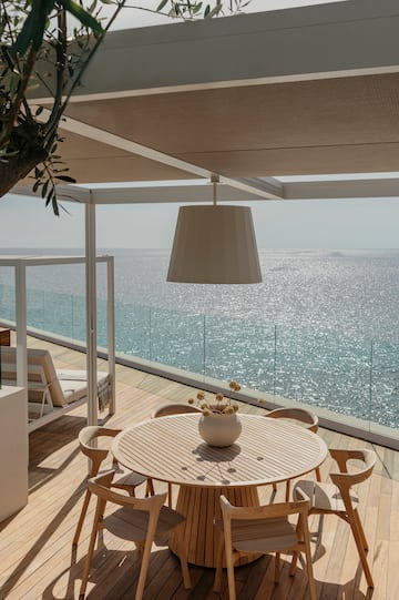 a table and chairs on a deck overlooking the ocean
