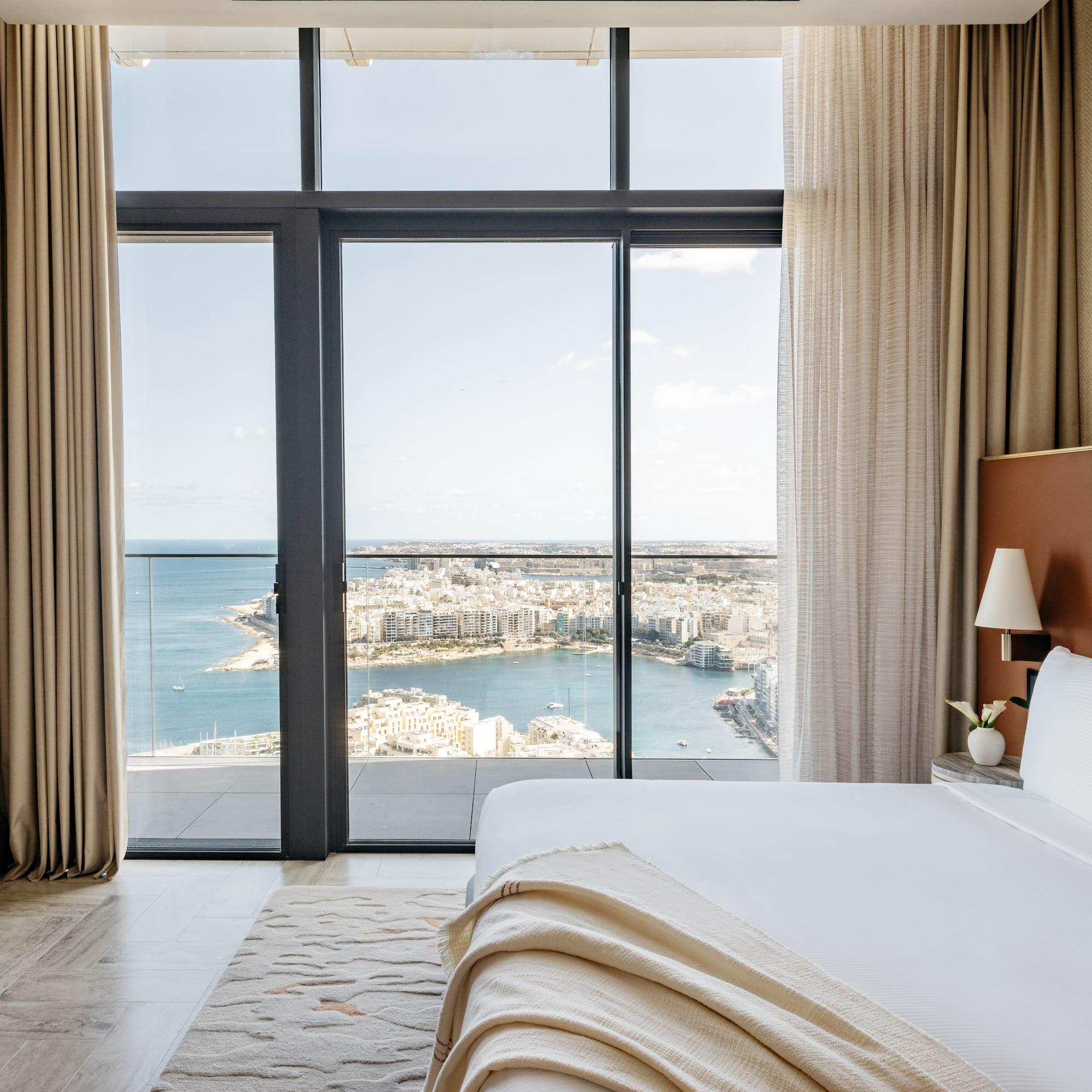 a bedroom with a view of a city and a bay