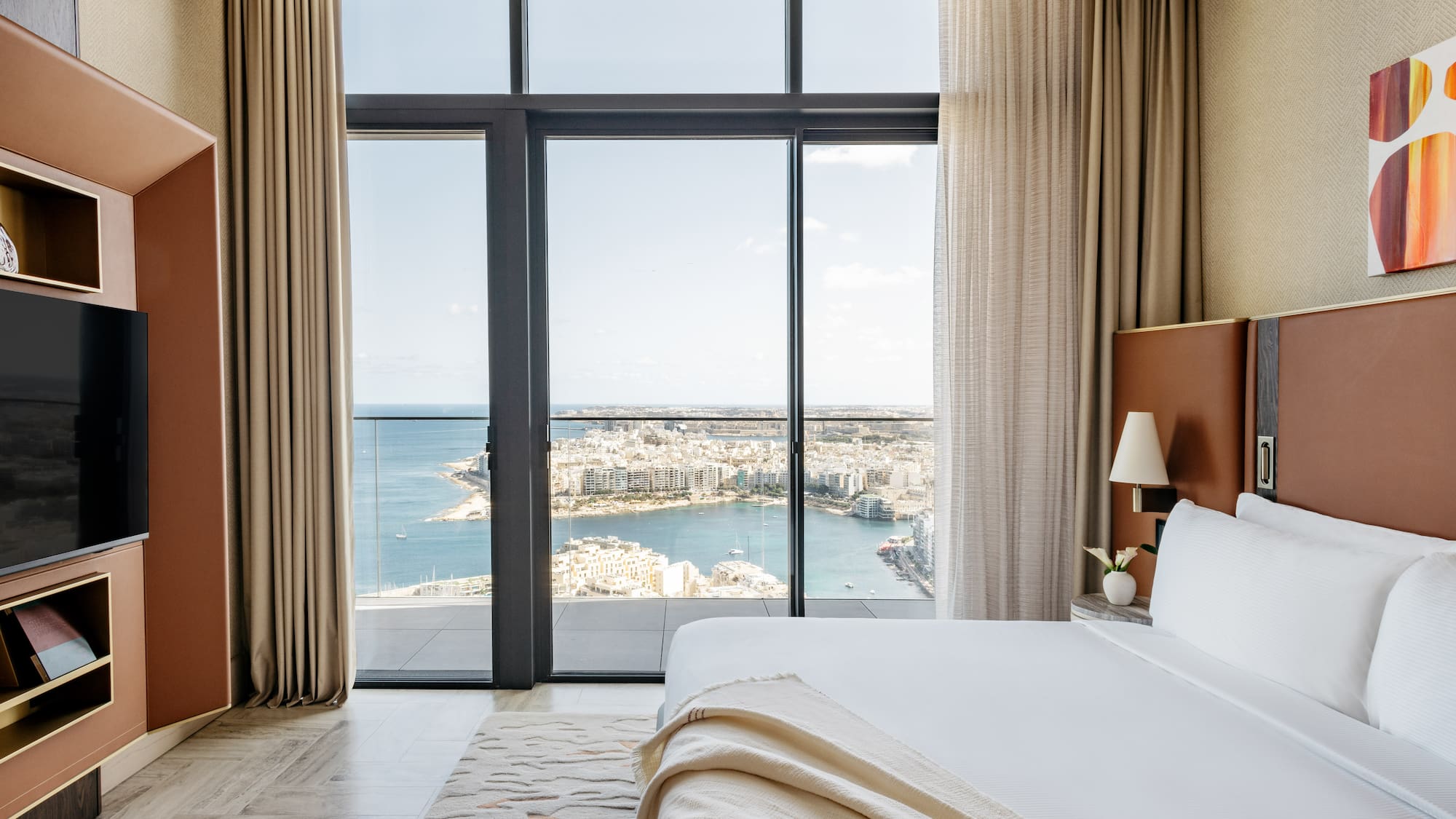 a bedroom with a view of a city and a bay