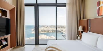 a bedroom with a view of a city and a bay