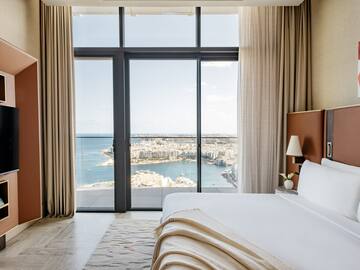 a bedroom with a view of a city and a bay