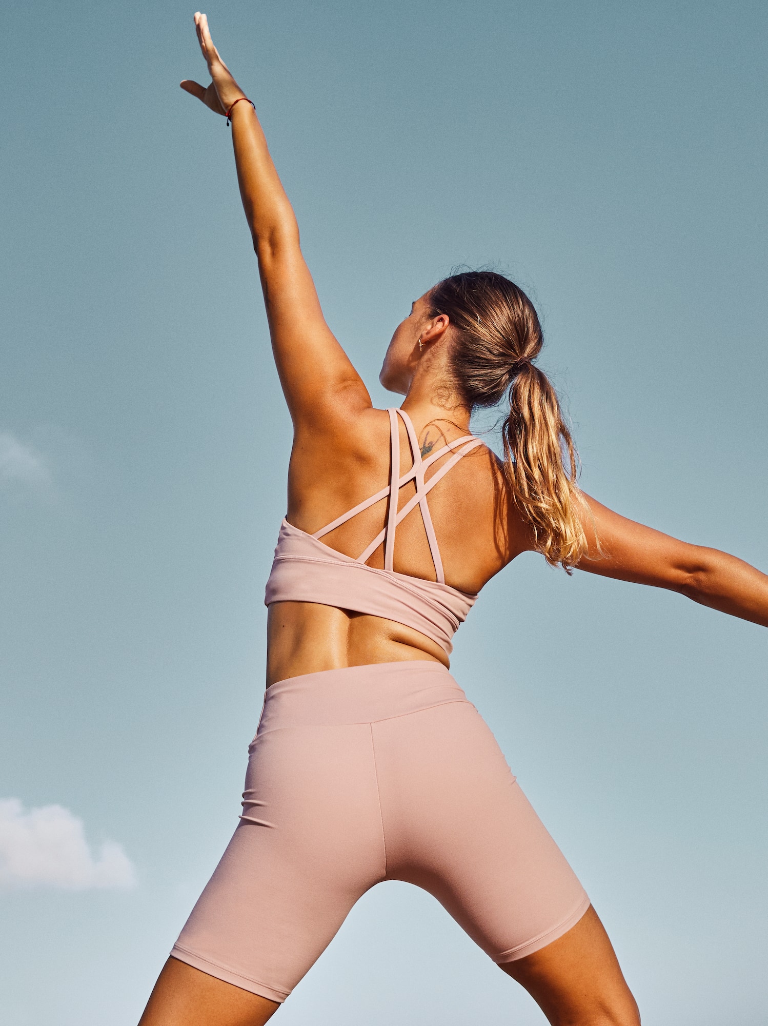 a woman in pink outfit with arms outstretched