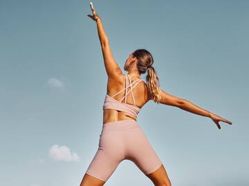 a woman in pink outfit with arms outstretched