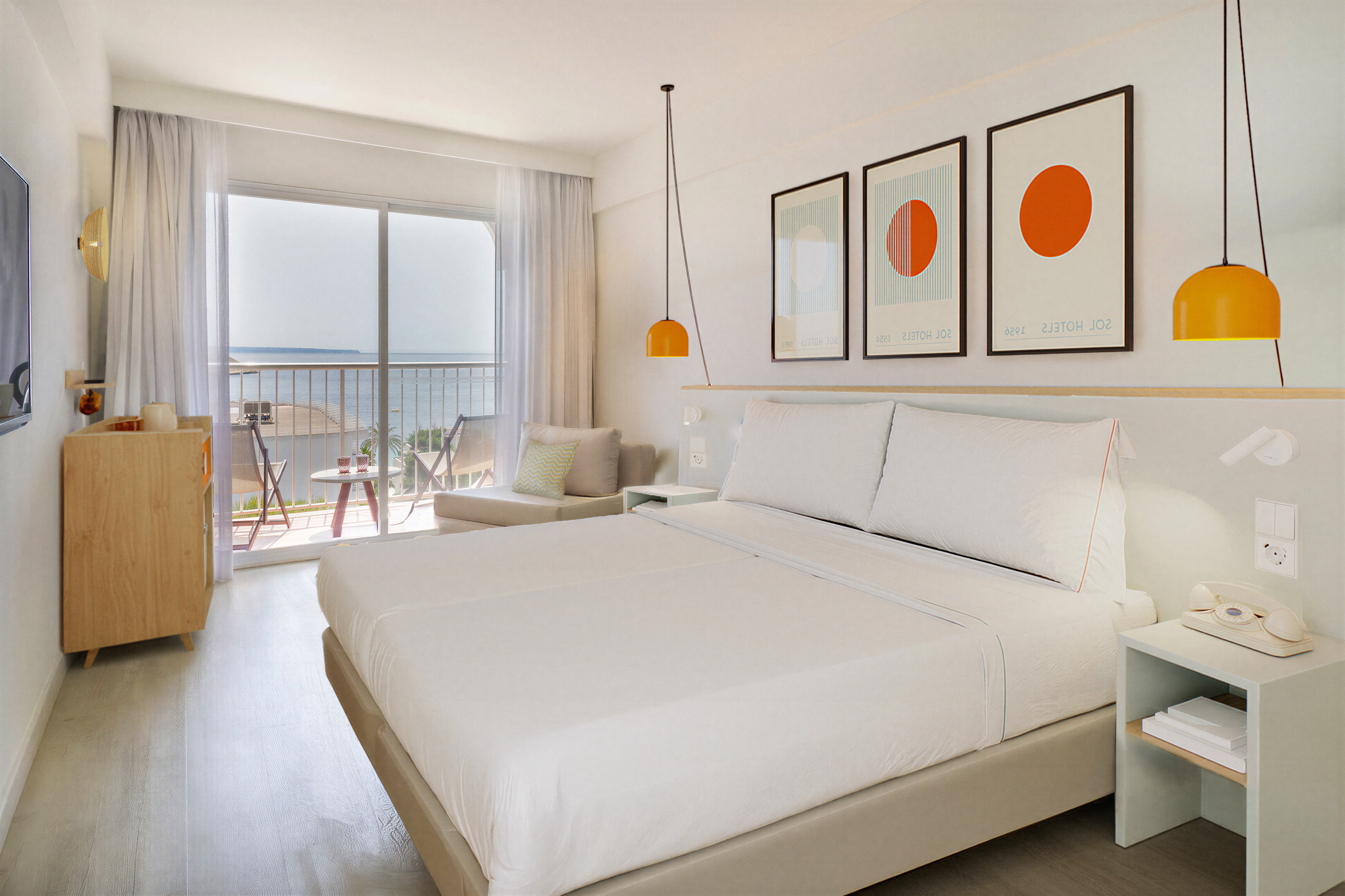 Modern hotel room with sea view balcony, white bed, and vibrant design.