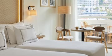 a hotel room with two beds and a table and chairs