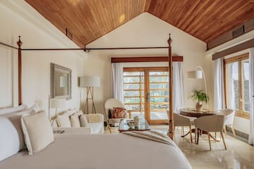 a bedroom with a bed and a table and chairs