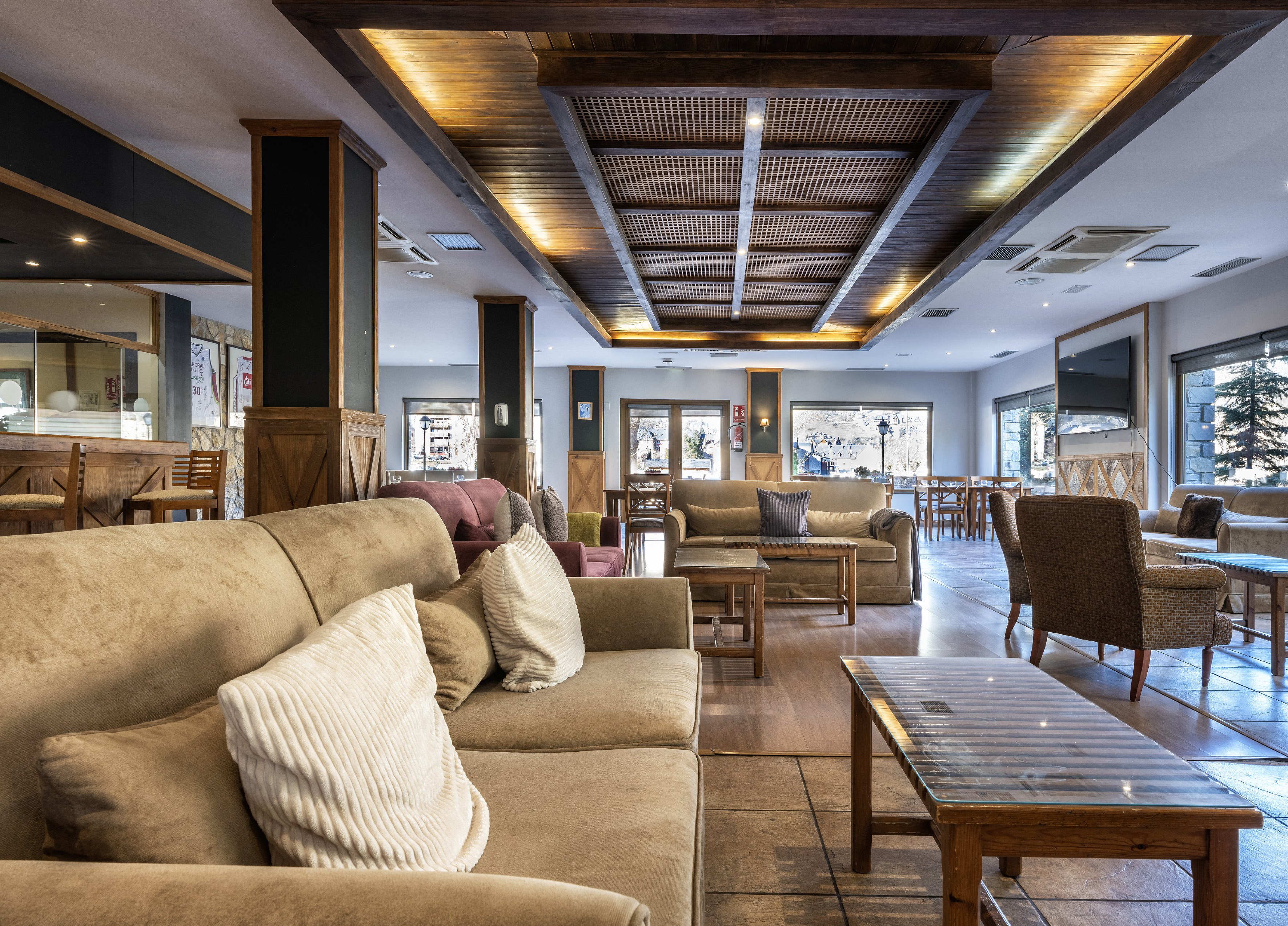 Cozy hotel lounge with comfortable sofas and rustic wooden ceiling.