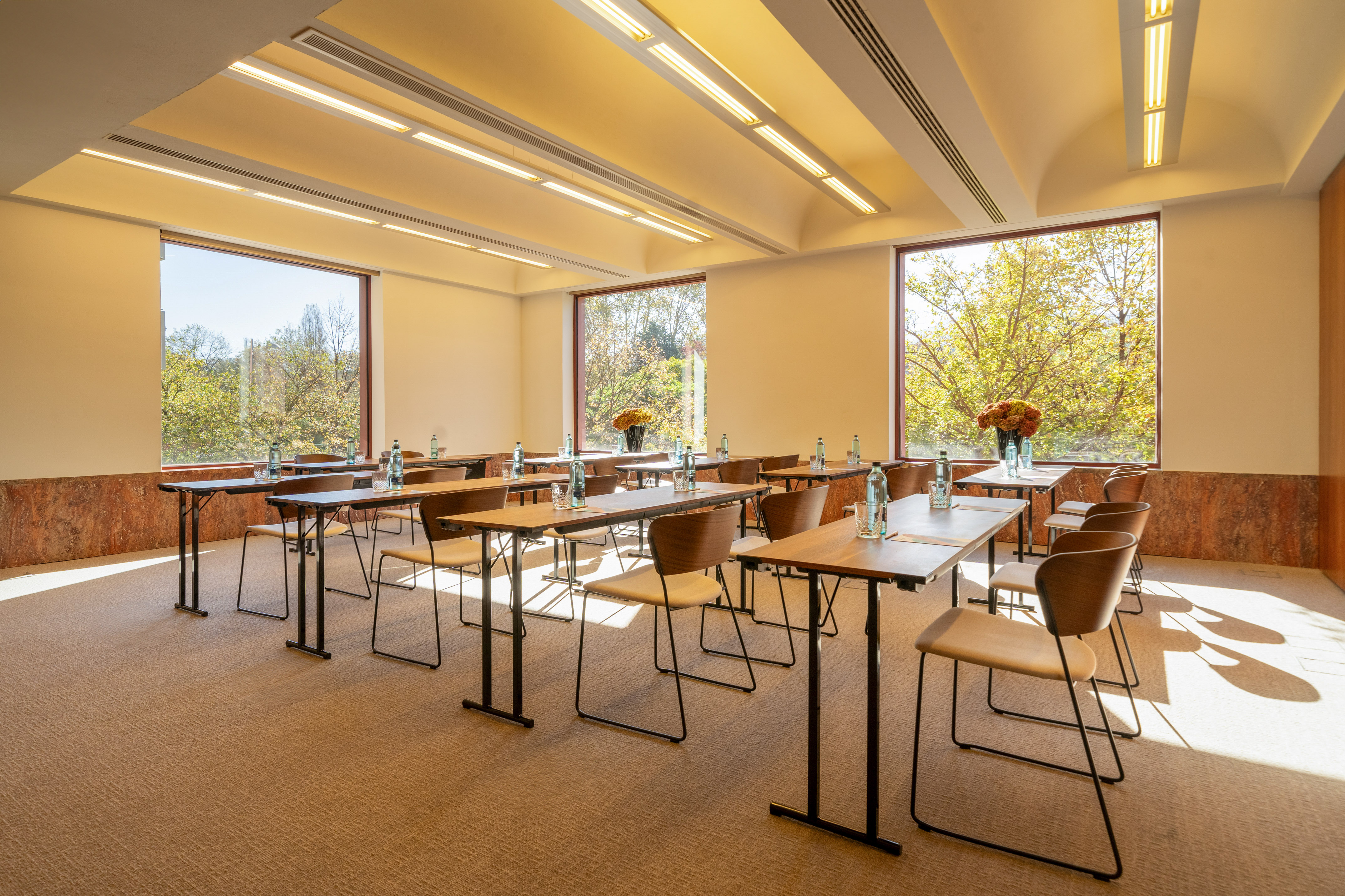 Bright, modern conference room with tables, chairs, and large windows.