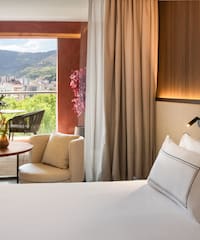 a room with a bed and a table and chairs