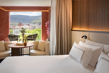 a room with a bed and a table and chairs