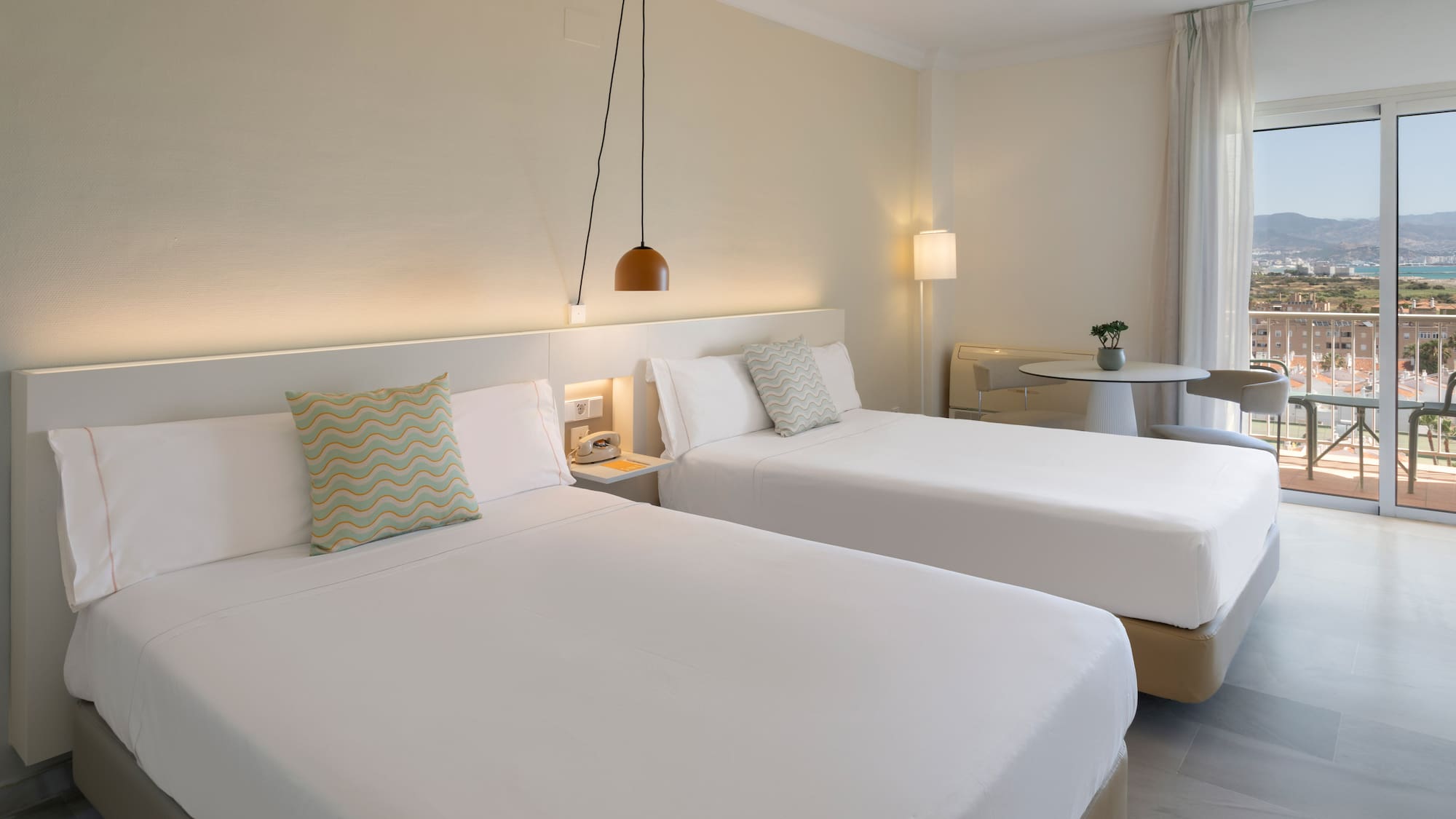 Habitación doble hotel, camas individuales, balcón y vistas costeras.