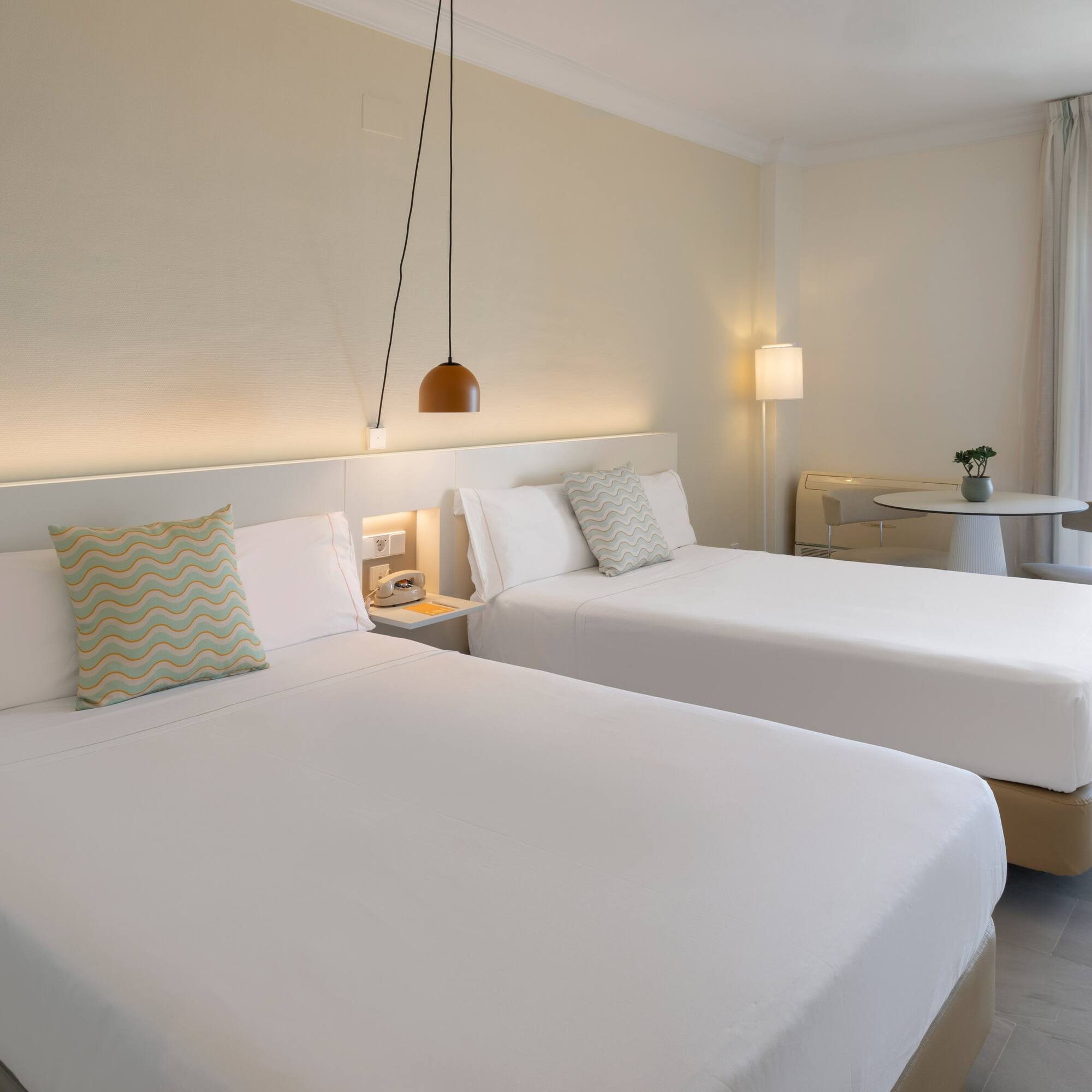 Habitación doble hotel, camas individuales, balcón y vistas costeras.