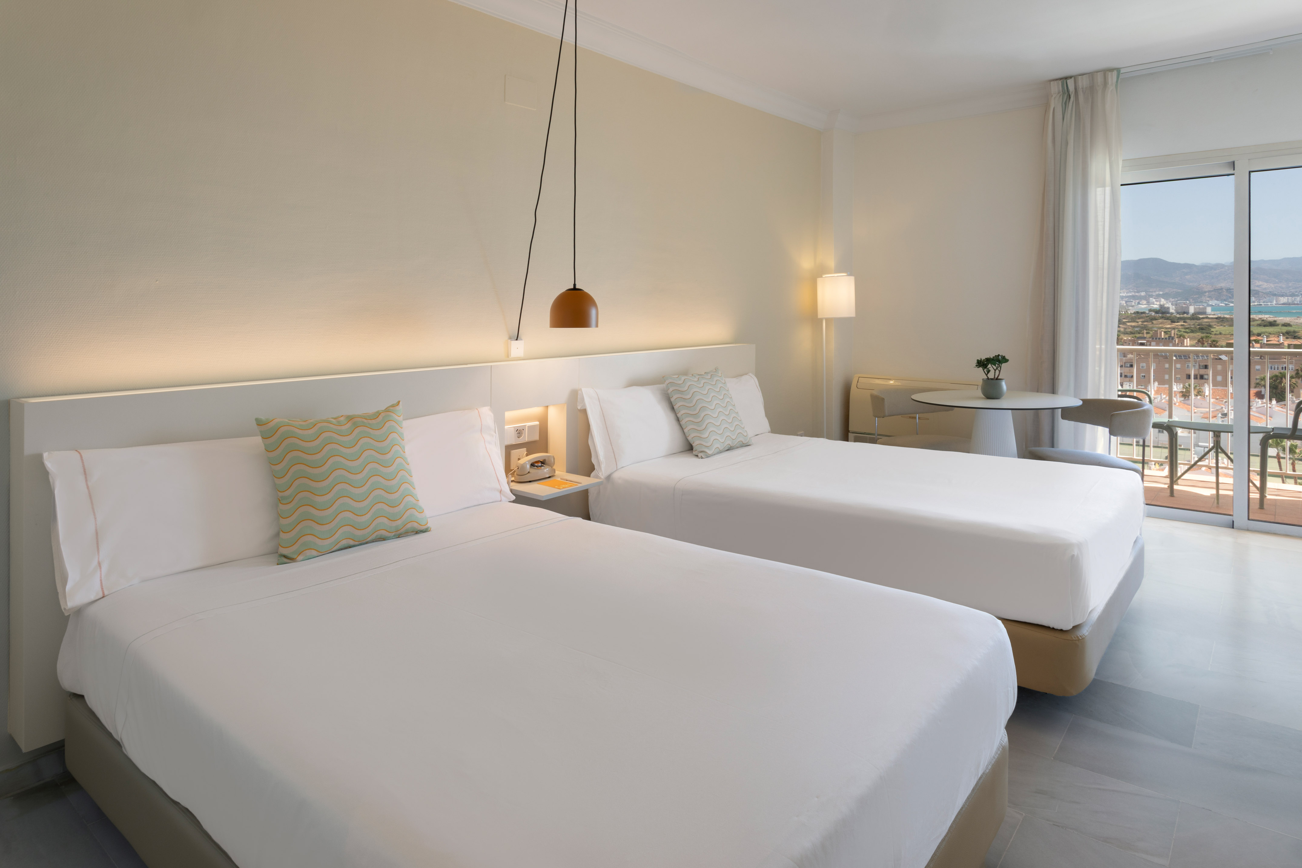 Habitación doble hotel, camas individuales, balcón y vistas costeras.