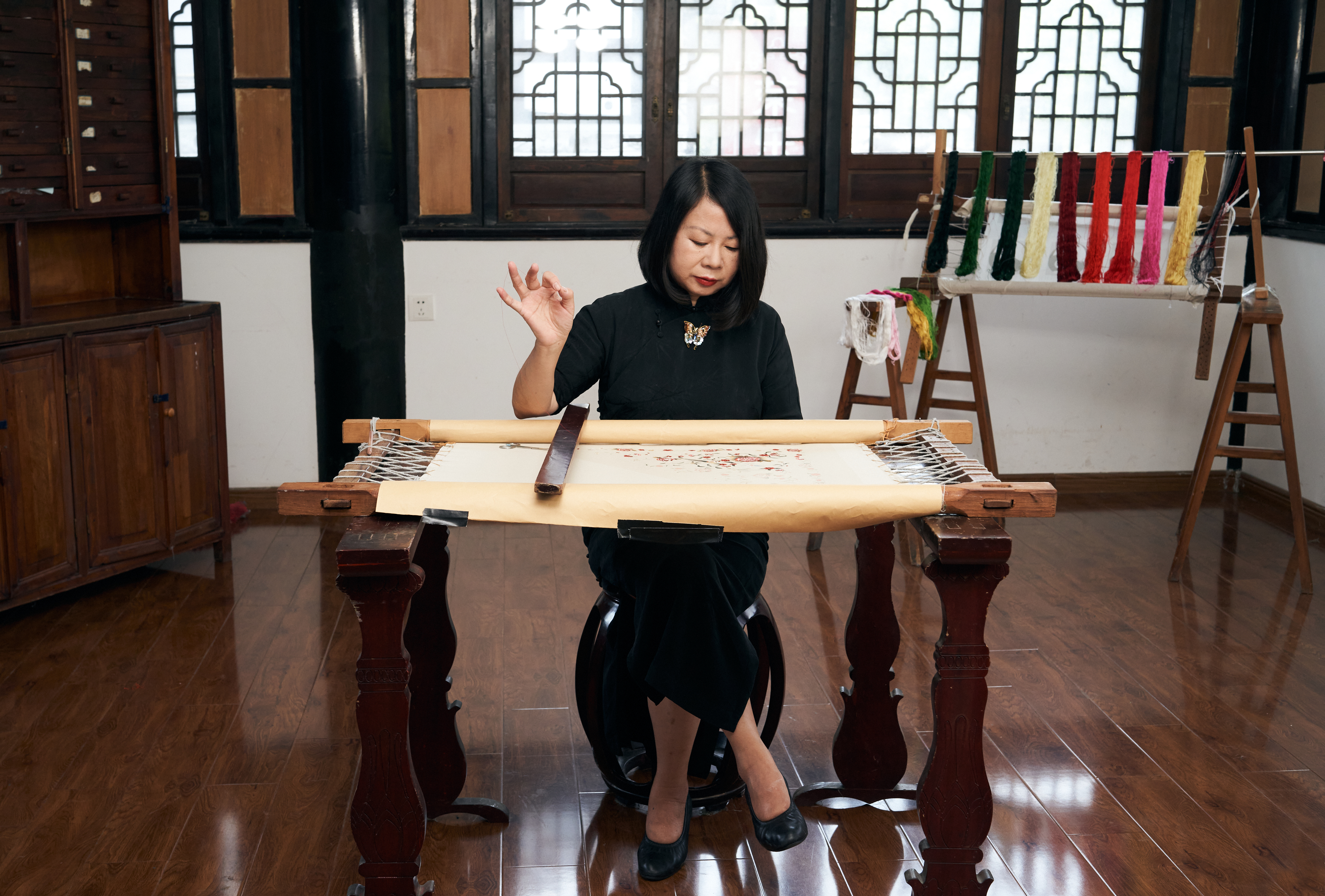 a woman sitting at a table with a scroll