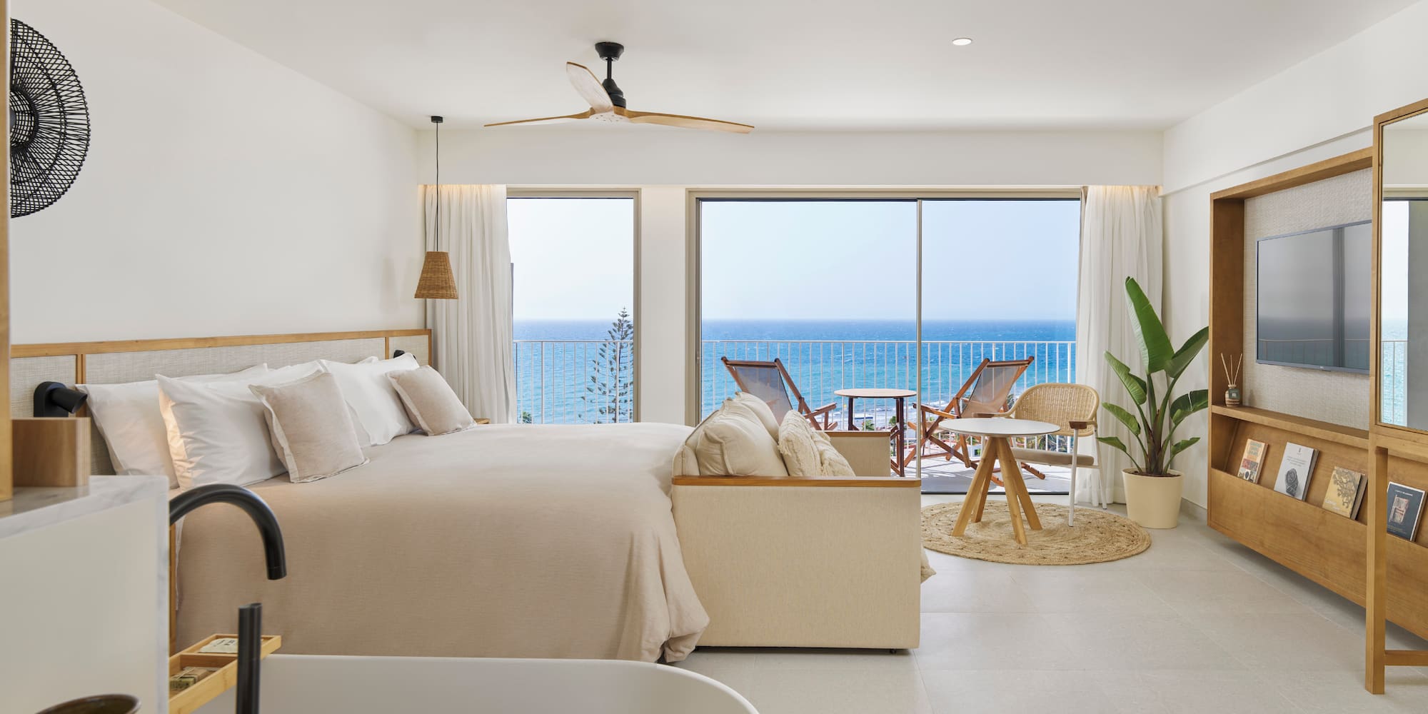 a bedroom with a large bed and a tub