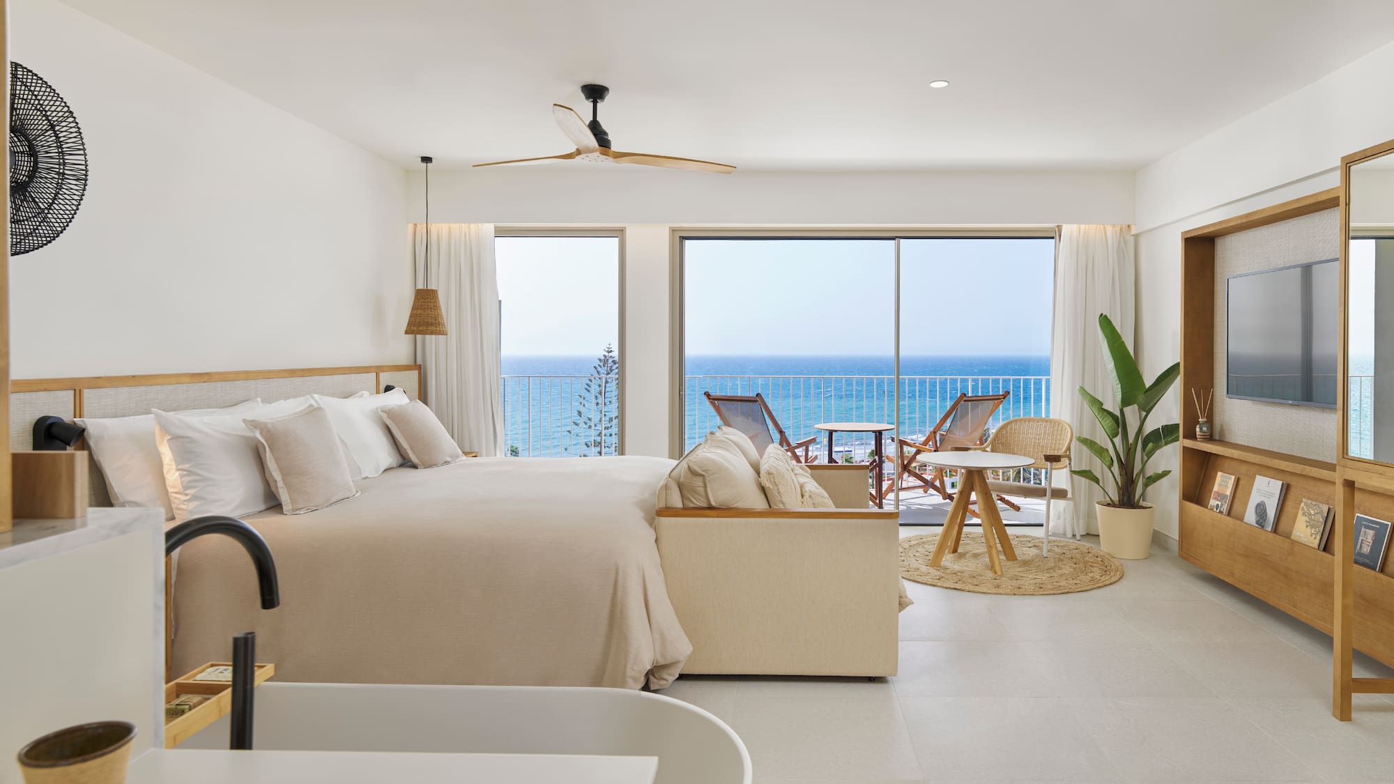 a bedroom with a large bed and a tub