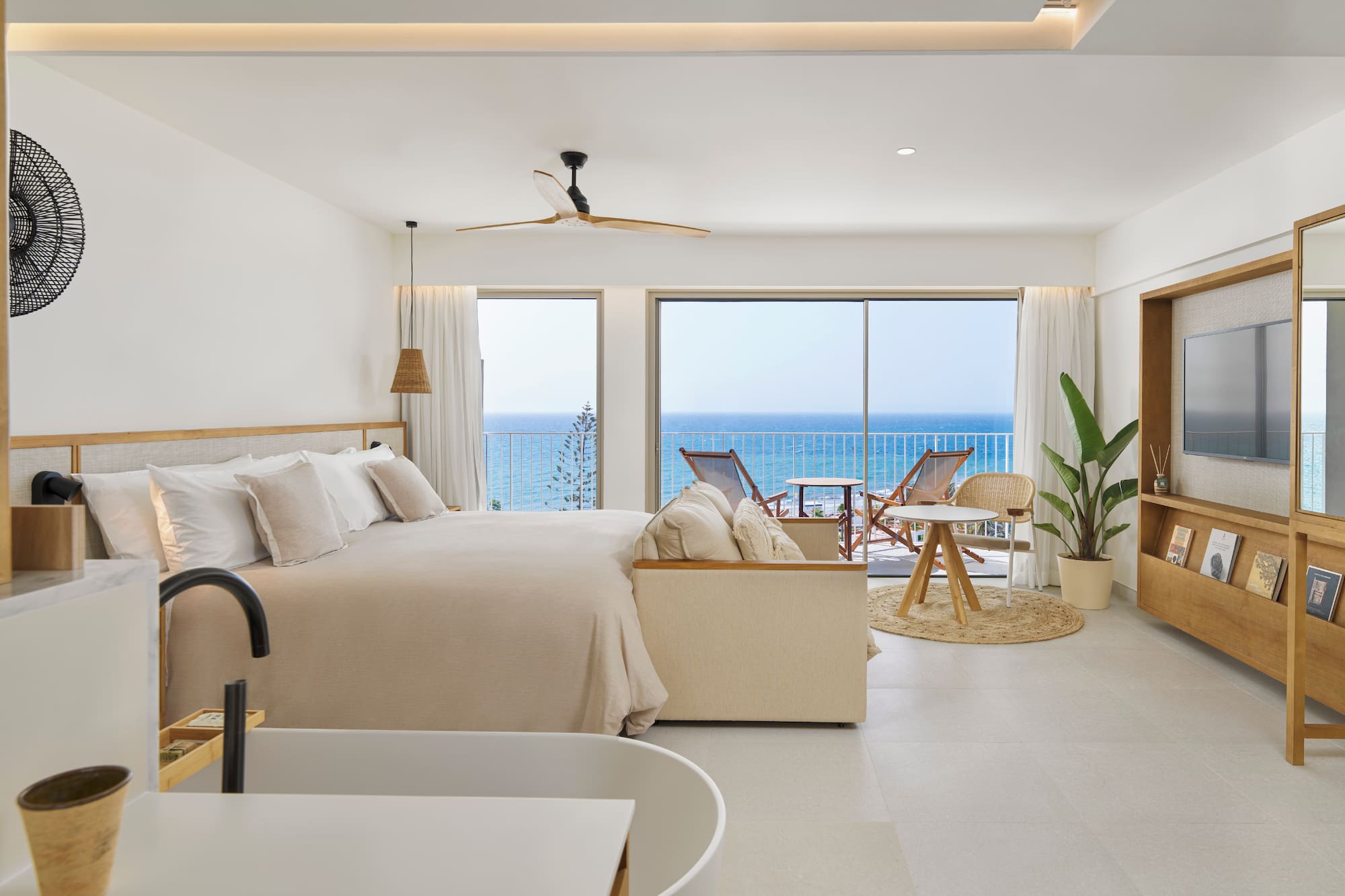 a bedroom with a large bed and a tub