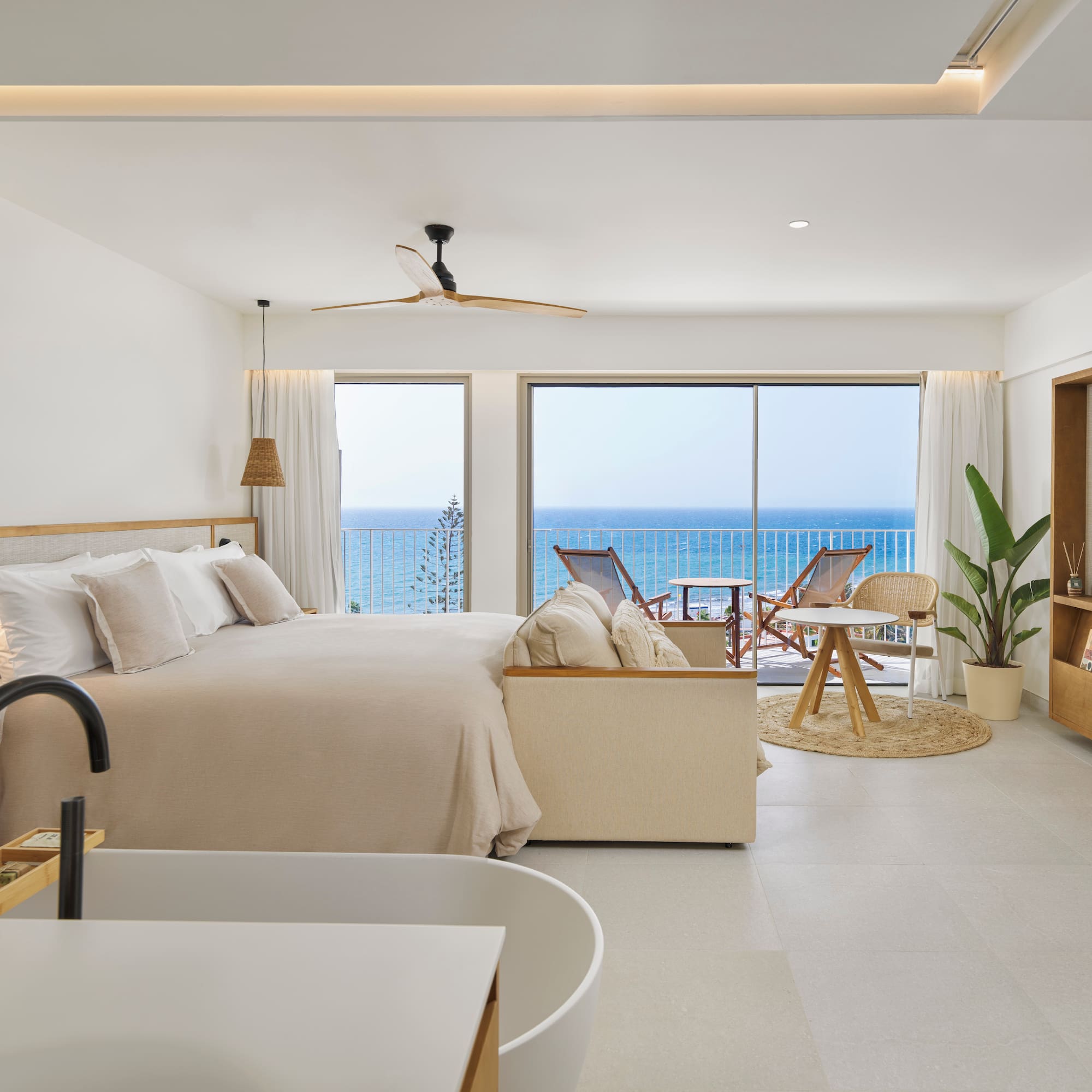 a bedroom with a large bed and a tub