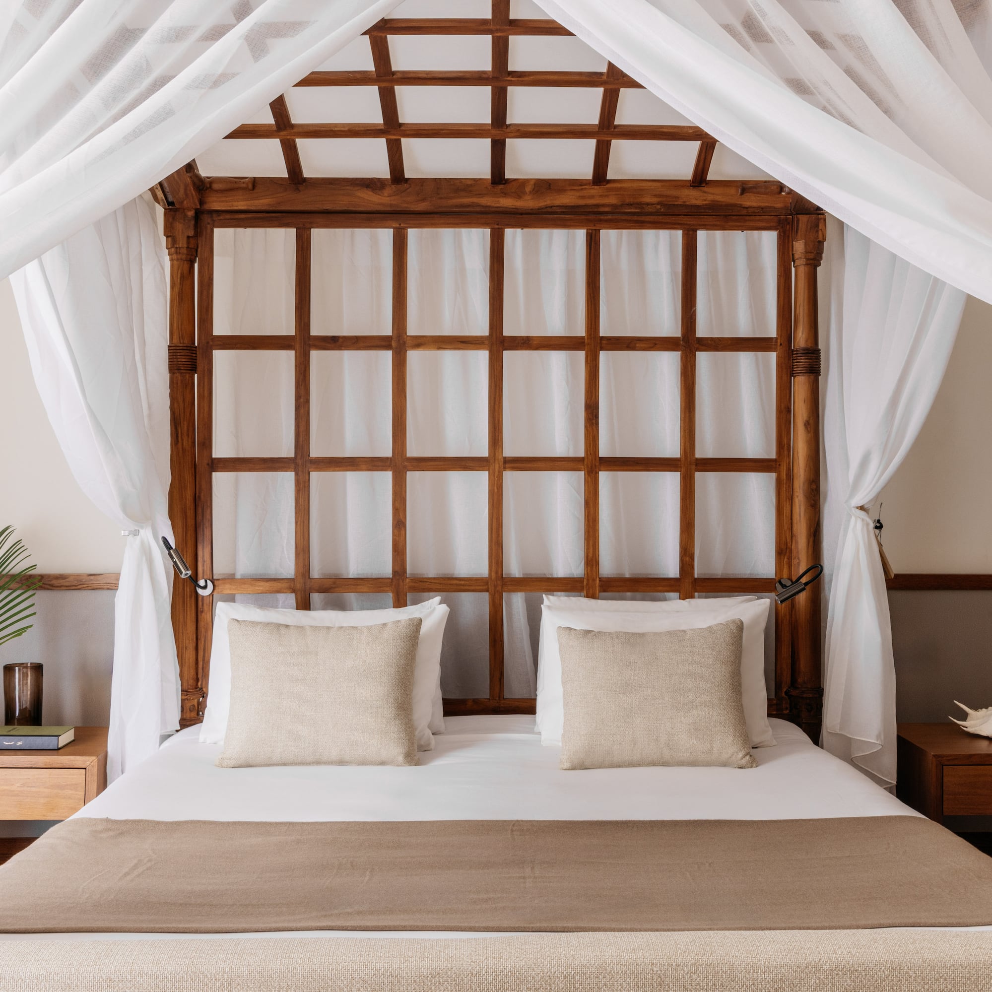 a bed with white curtains and a wooden canopy over it