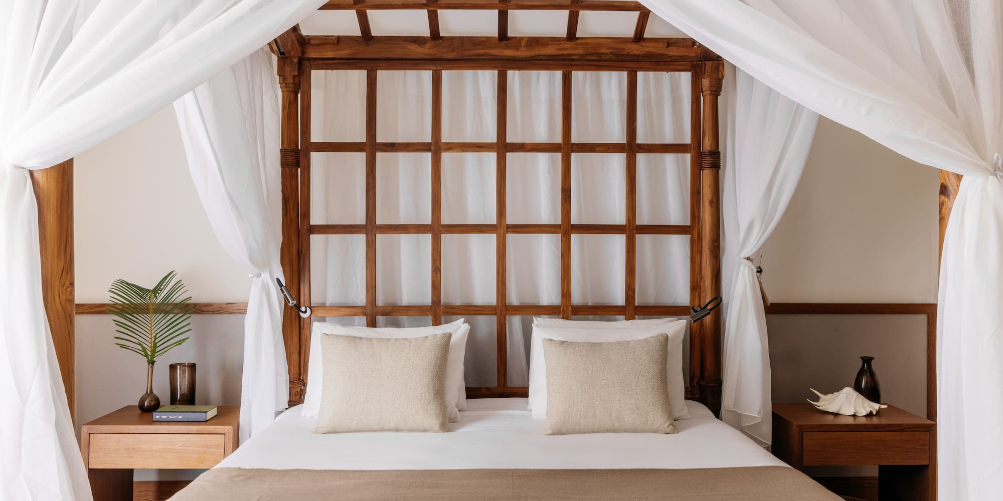 a bed with white curtains and a wooden canopy over it