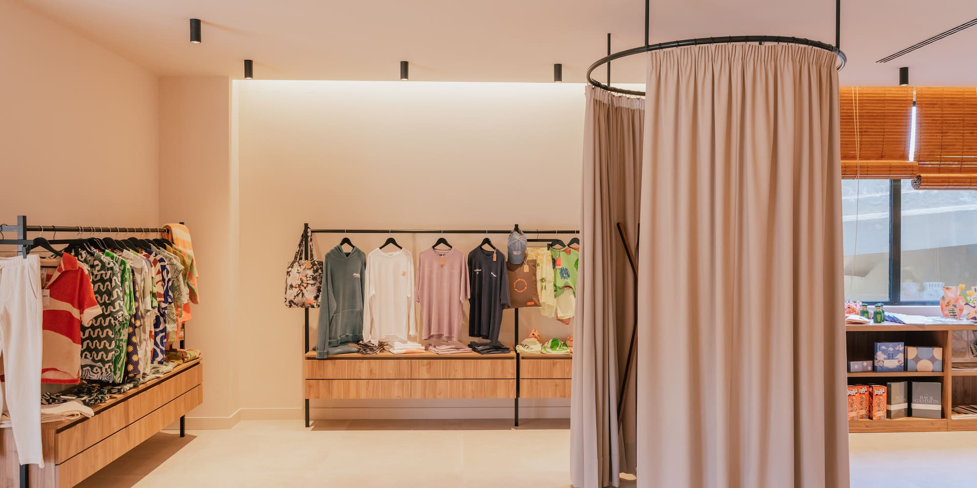 a room with a round clothing rack and a curtain