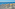 a group of lounge chairs and umbrellas on a beach