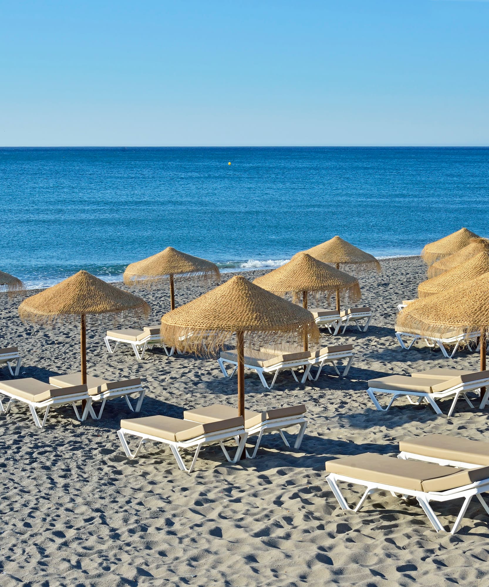 a group of lounge chairs and umbrellas on a beach