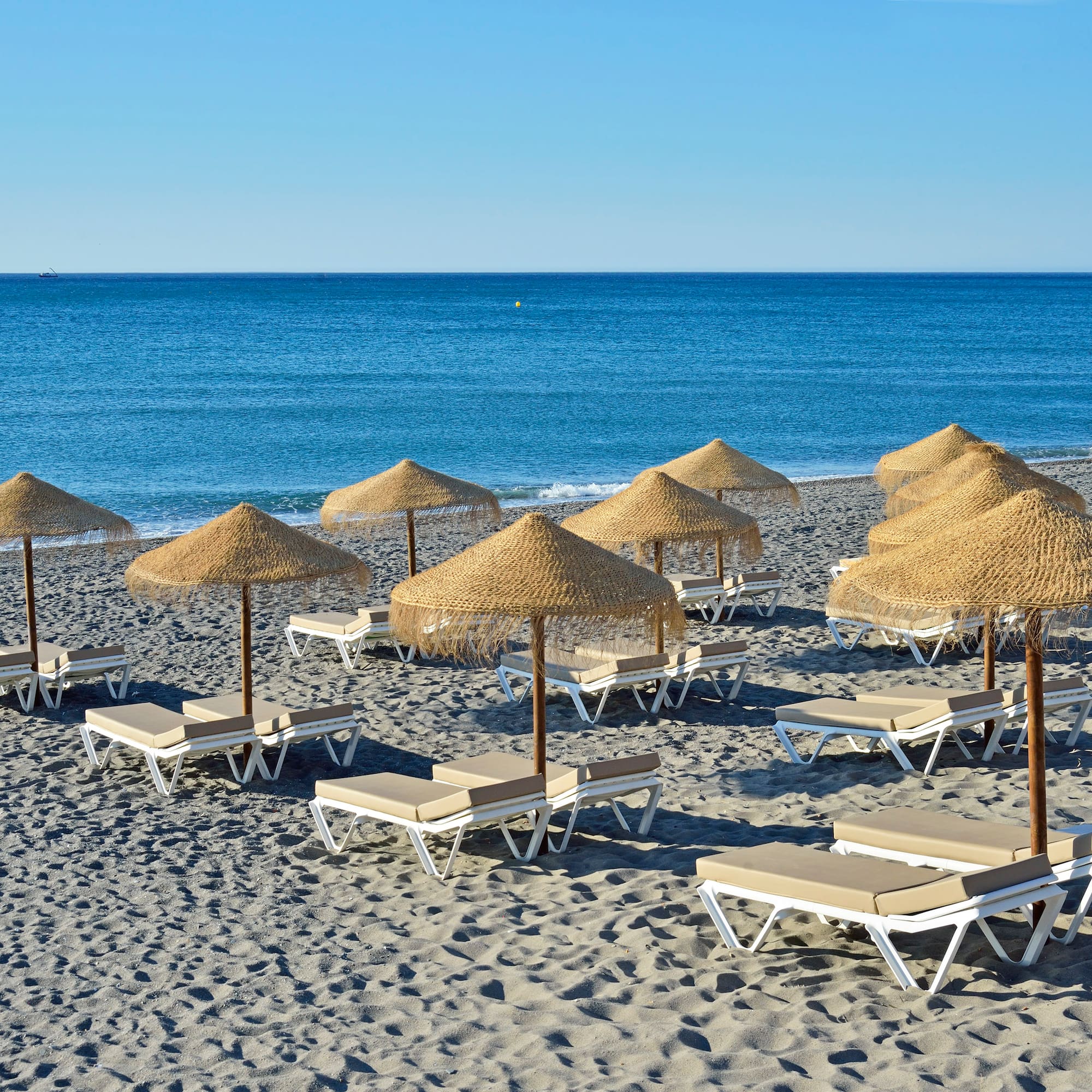 a group of lounge chairs and umbrellas on a beach