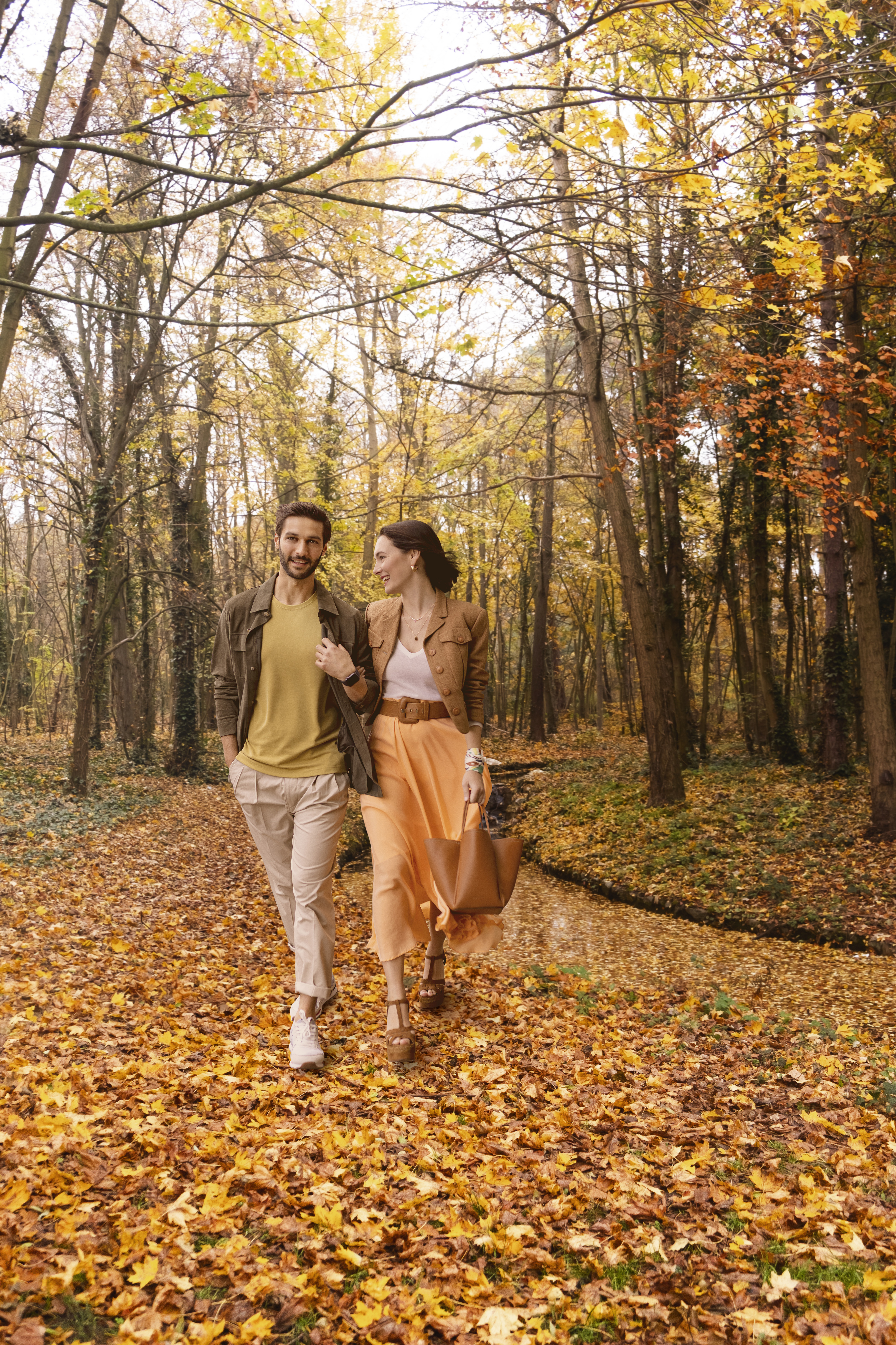 a man and woman walking in a forest