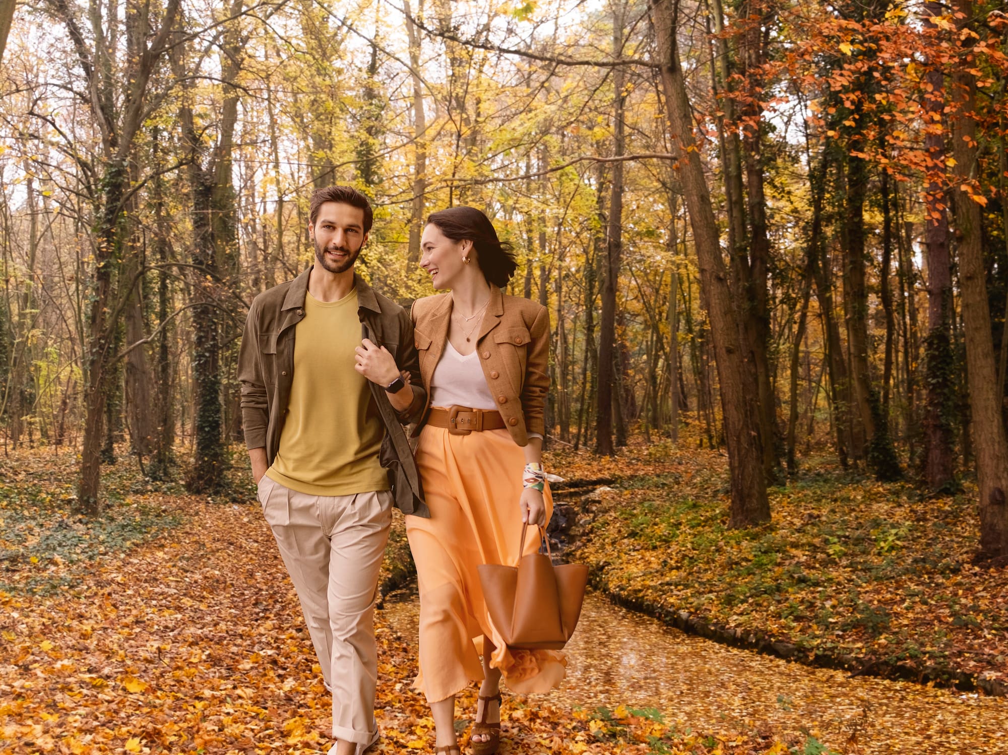 a man and woman walking in a forest